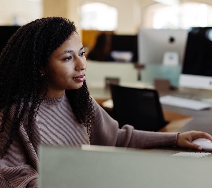 a graphic design student sitting at a computer