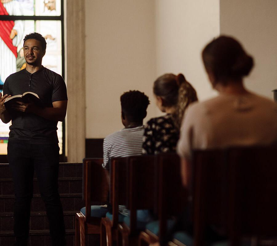 Student reads the bible at the front of chapel.