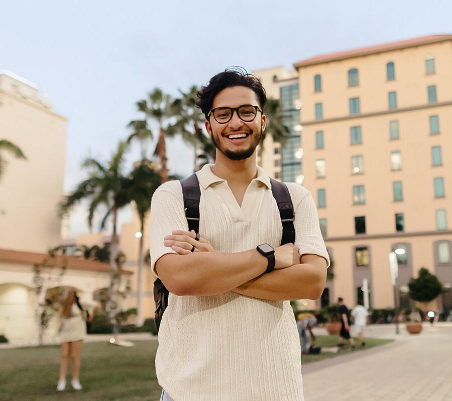 biblical studies minor student stands with arms folded on 的 PBA campus.